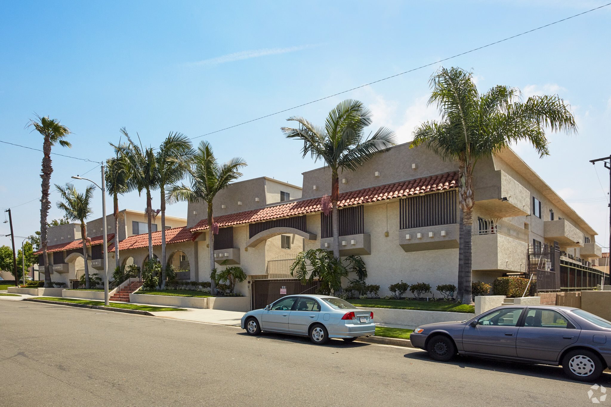 a view of the house from across the street with two cars parked in front of it